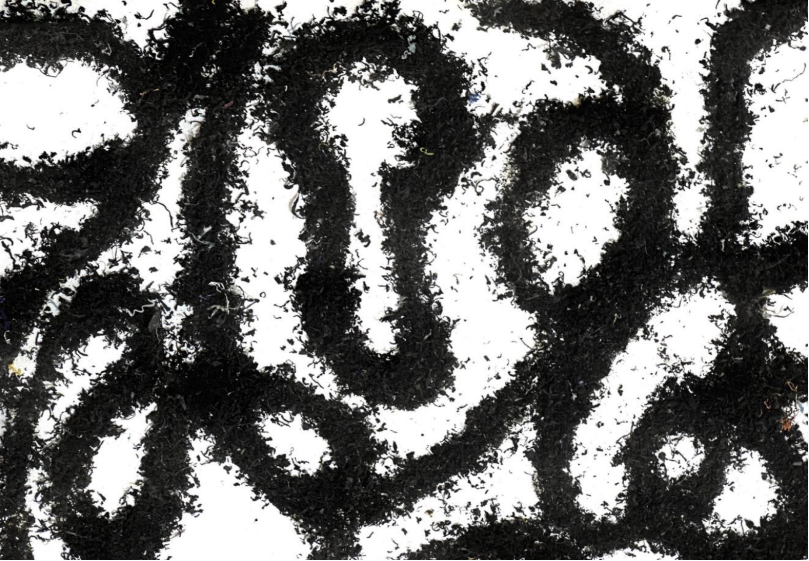 Close view of shredded recycled plastic embedded in a white artwork surface